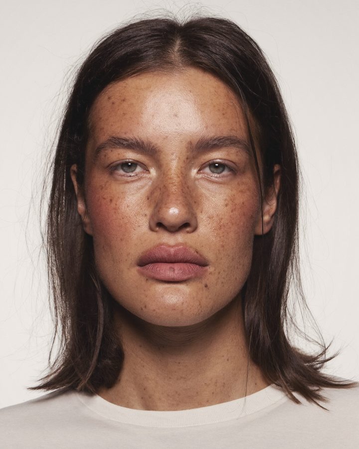 Visage sans maquillage, pores et taches de rousseur visibles